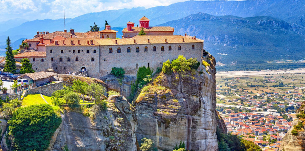 Monastery perched atop a rock formation in Meteora, Greece, surrounded by mountains, a highlight of a winter mainland tour.