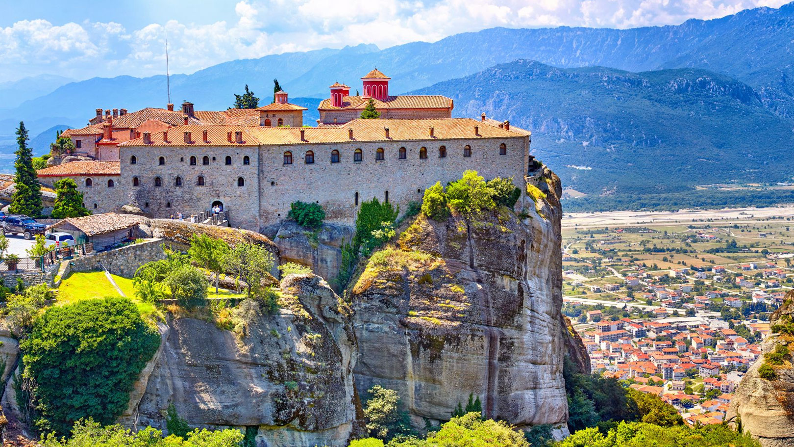Monastery perched atop a rock formation in Meteora, Greece, surrounded by mountains, a highlight of a winter mainland tour.