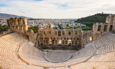 The ancient Odeon of Herodes Atticus amphitheater on the Acropolis hill with panoramic views of Athens city.