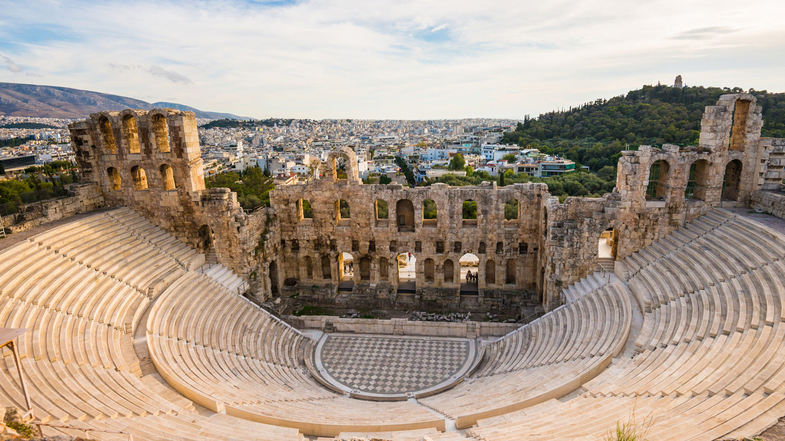 The ancient Odeon of Herodes Atticus amphitheater on the Acropolis hill with panoramic views of Athens city.