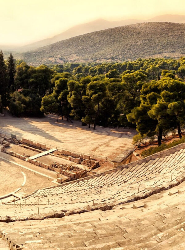 Ancient open-air theatre of Epidaurus in Greece, surrounded by lush green trees and mountains, showcasing its iconic circular stage and stone seating.