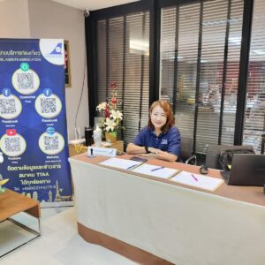 TTAA event registration desk with a representative welcoming attendees and promotional materials displayed in Bangkok.