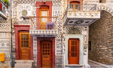 Traditional mastic village houses with geometric black-and-white patterns and wooden doors in Chios, Greece.