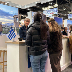 "Cosmorama DMC representative welcoming visitors and discussing Greece travel opportunities at FITUR 2026 in Madrid